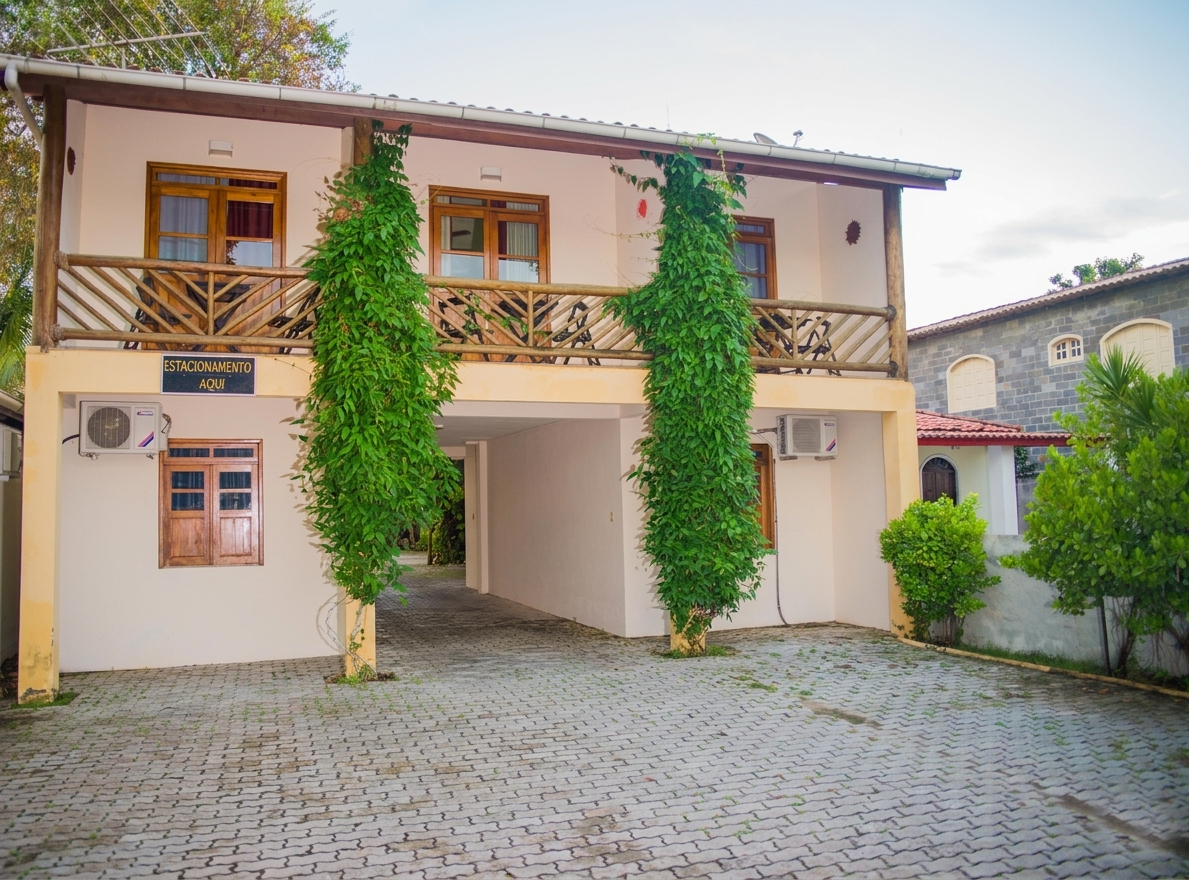 Vista frontal da pousada com vegetação verde