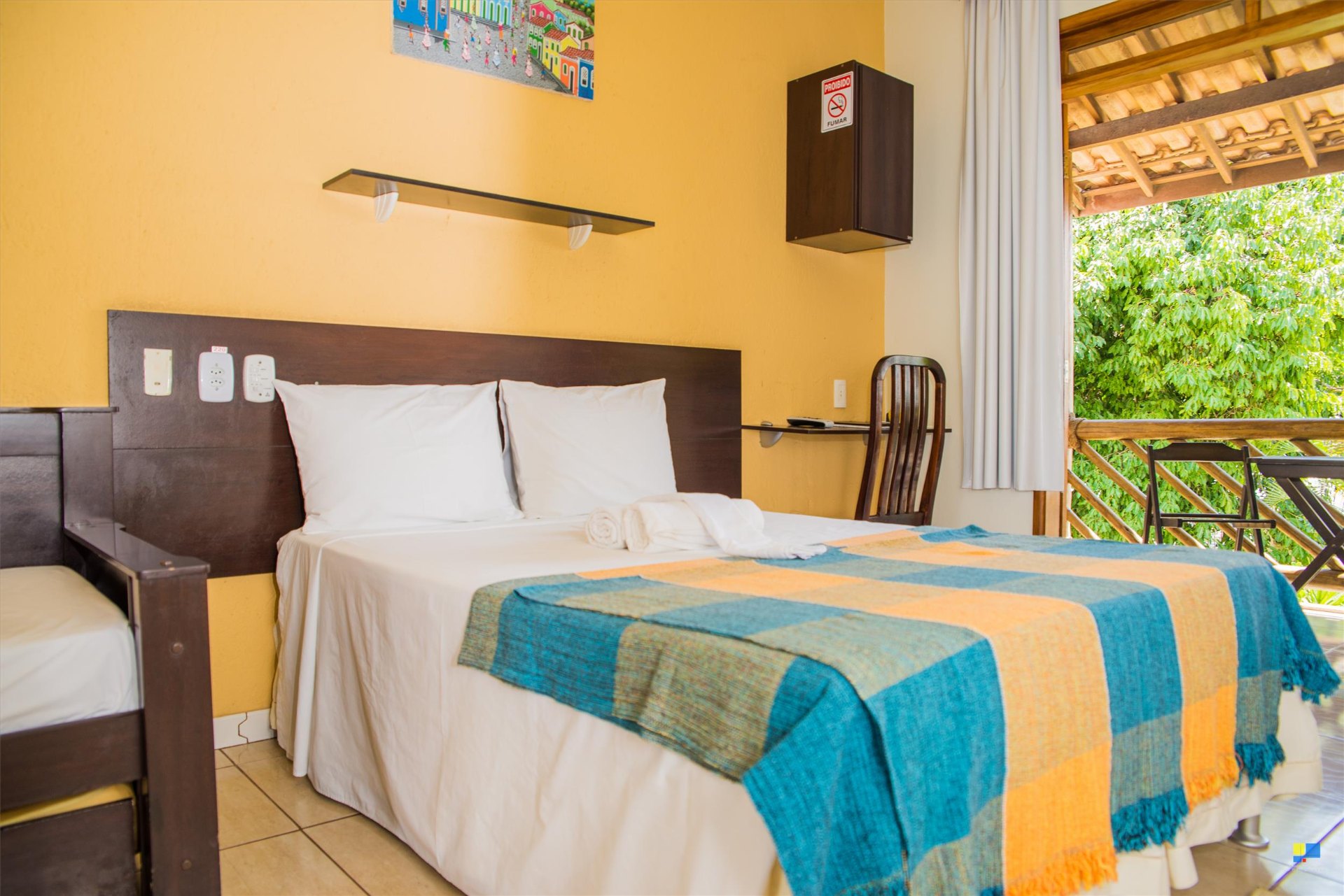 Quarto com cama de casal, varanda e vista verde