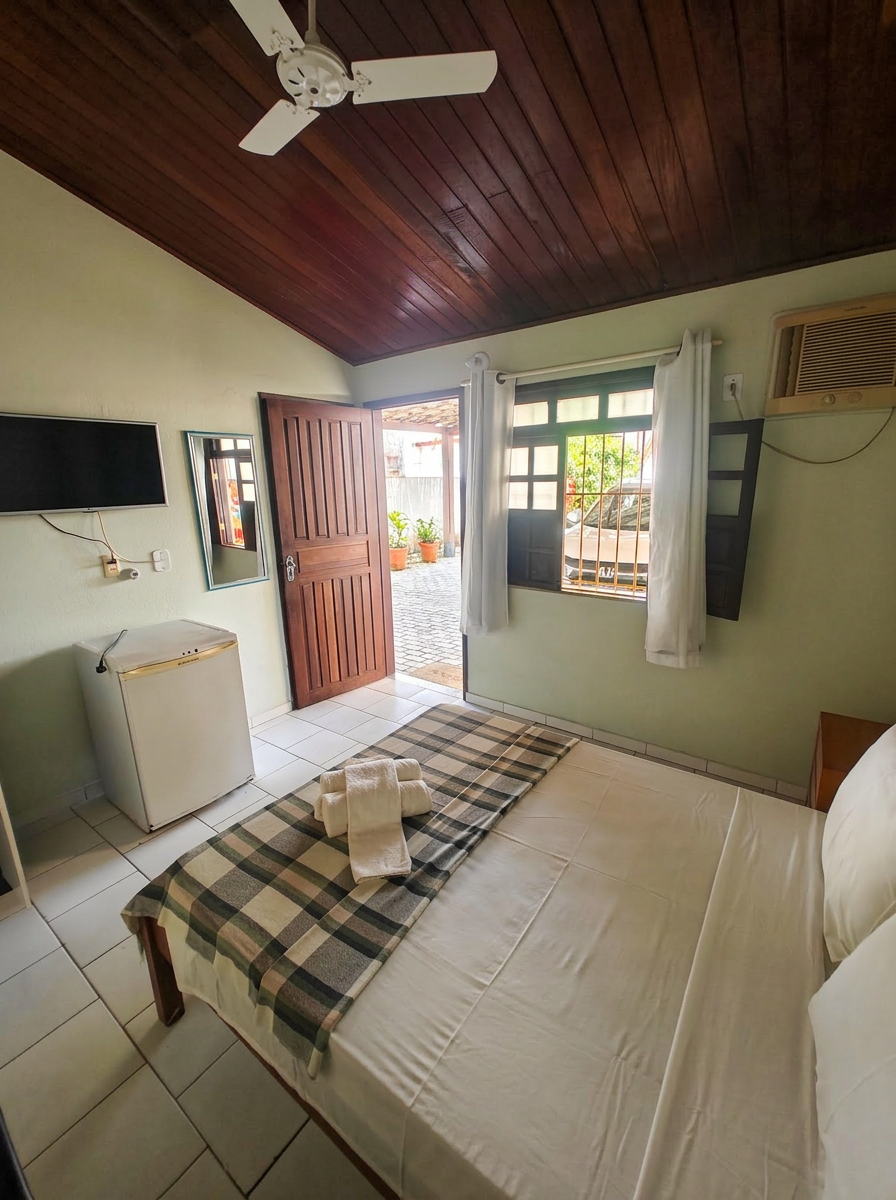 Quarto com teto de madeira, ventilador e ar-condicionado